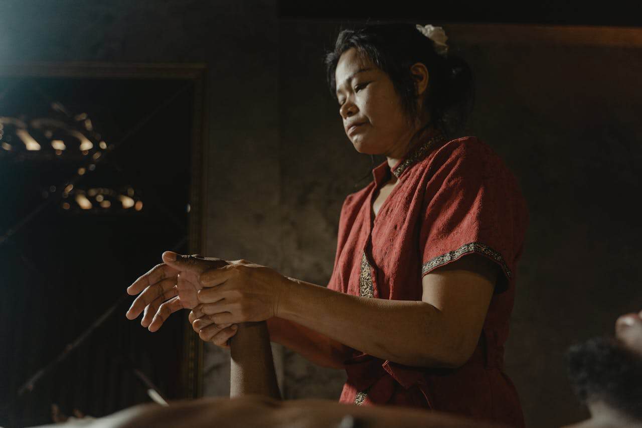 A masseuse providing a relaxing hand massage at a tranquil spa, promoting wellness and rejuvenation.