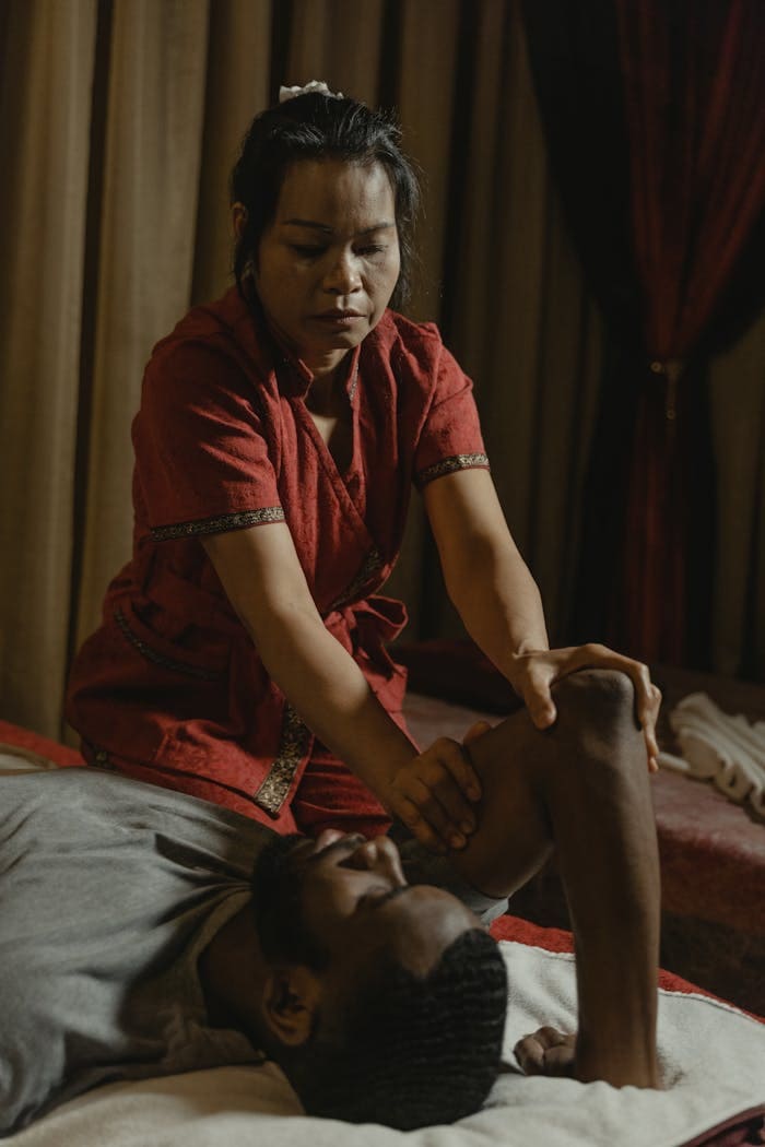 A focused therapist giving a therapeutic massage to a client in a serene spa setting.